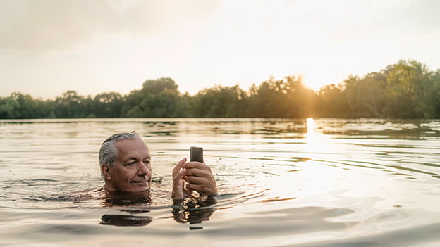 Mann am Handy im Wasser